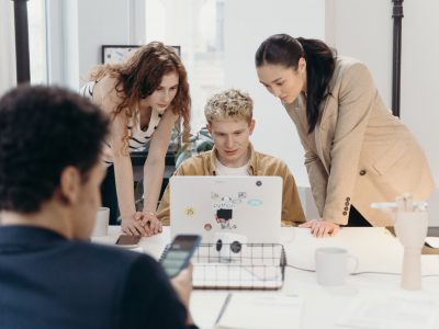 Grupo de jovens conversando com um computador ao redor de uma mesa