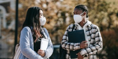 alunos andando pelo campus em uma universidade pública